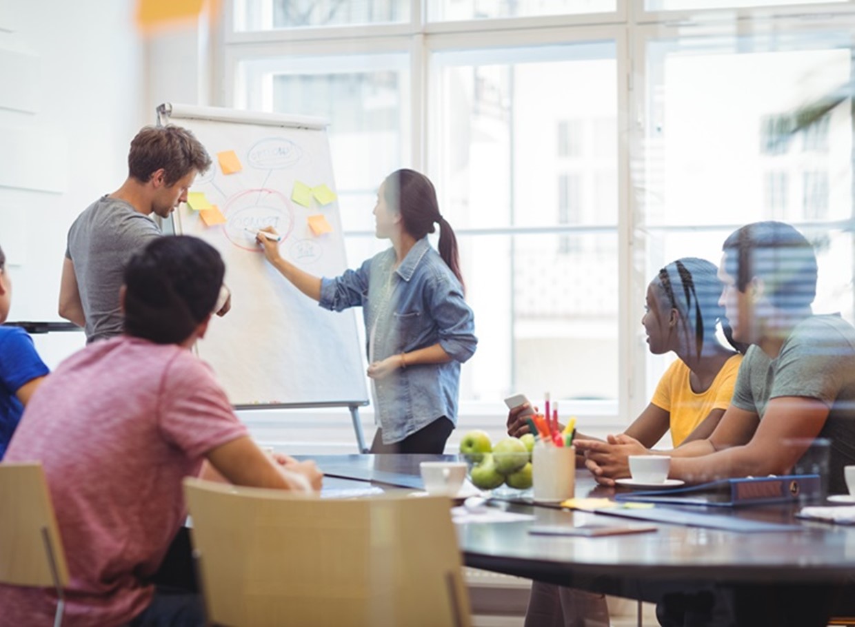 Business Executives Discussing With Their Colleagues On Whiteboa (1)